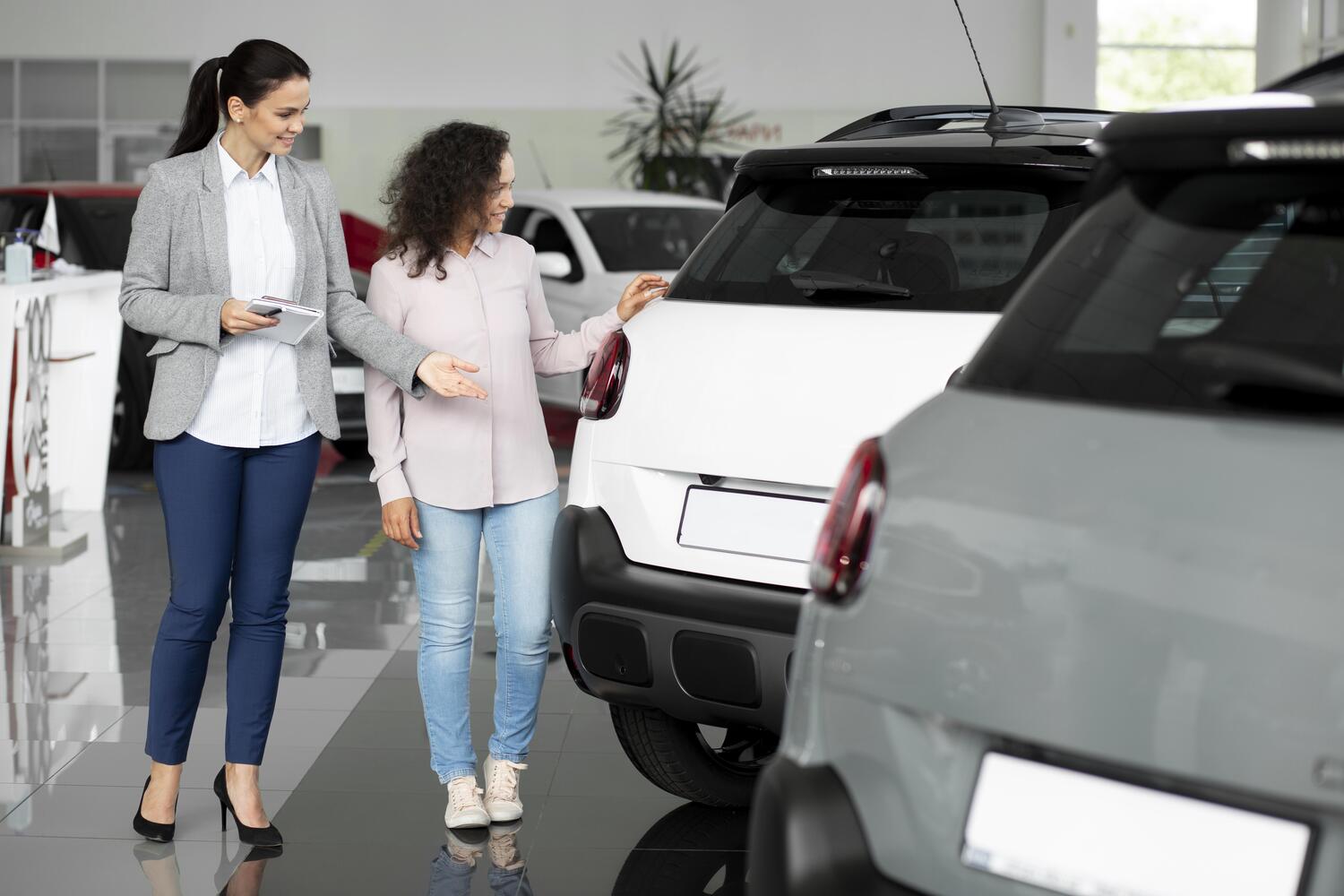 Une femme en aide une autre à choisir sa voiture.